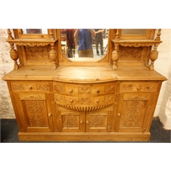  Large Victorian style waxed pine mirror back sideboard, carved pediment, stepped projecting cornice above three mirrors, turned and acanthus carved baluster supports, break bow front above four drawers and cupboards with relief carved panelled doors, plinth base, W182cm, H250cm, D49cm  