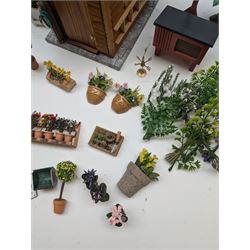 1:12 scale dolls house allotment and garden accessories, including wooden shed on a stone effect base, two vegetable patches, terracotta plant pots with flowers and foliage, stone effect plant pots, other planters, loose sunflowers, scarecrow, rabbit hutch, garden tools, fencing panels, etc 