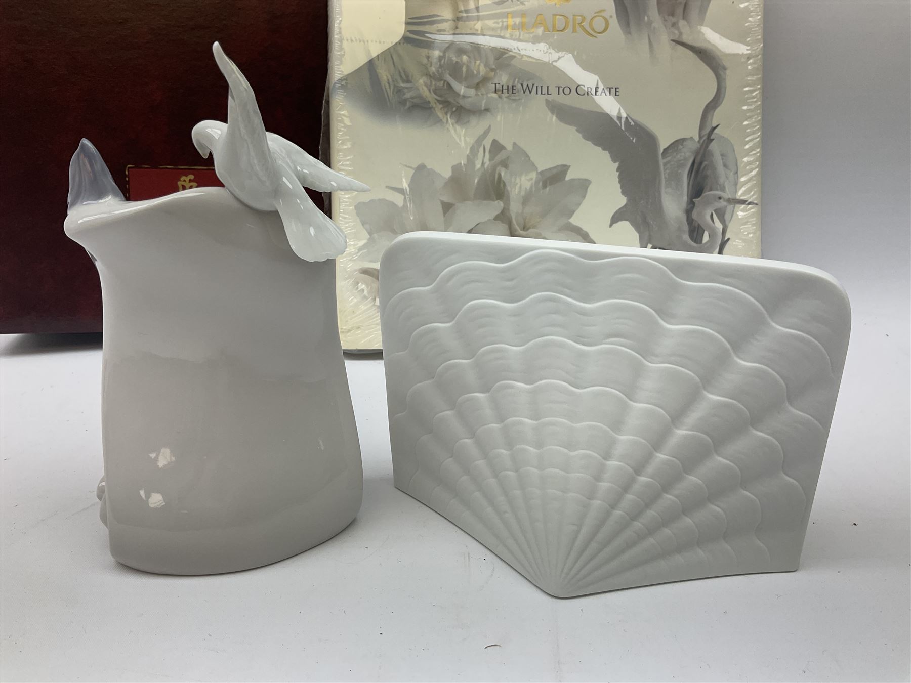 Lladro Collectors Society items, comprising of The Will to Create book, two candle holders; Sailing the Sea no 17665, Dolphins at Play no 17666, Plaque Bringing Us Together, key fob, leather wallet and a members joining pack with plaque, all in original boxes  