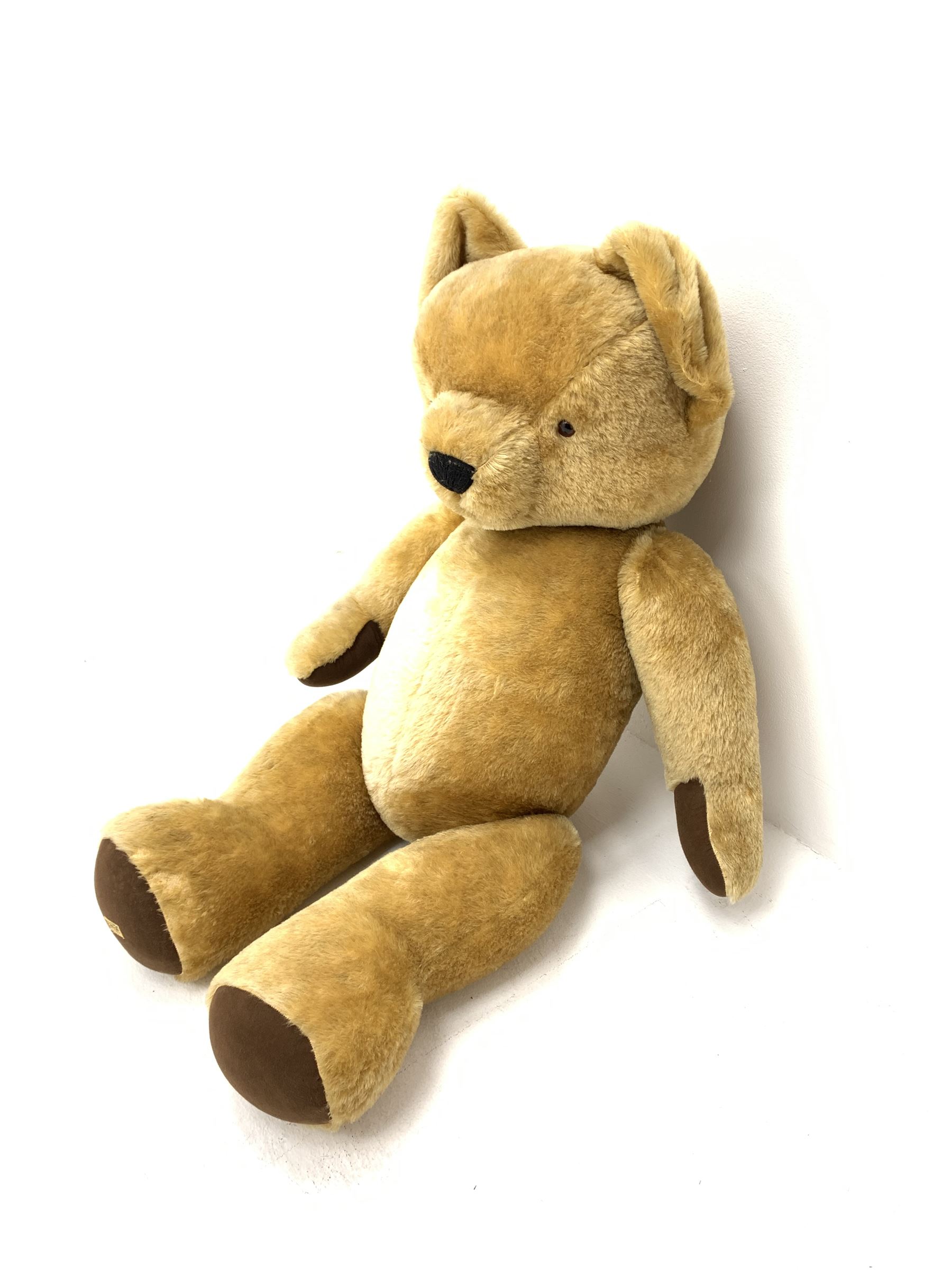 Very large Merrythought teddy bear with swivel jointed head, applied eyes, vertically stitched nose and mouth and jointed limbs with brown felt paw pads H50.5