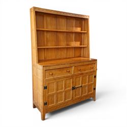 Rabbitman - adzed oak Welsh dresser, scalloped cornice above two plate racks, adzed and panelled sides, the lower integrated section with adzed oak top, over two drawers above twin cupboard doors with blackened metal latch and hinges, carved rabbit to the right hand side, by Peter Heap of Wetwang