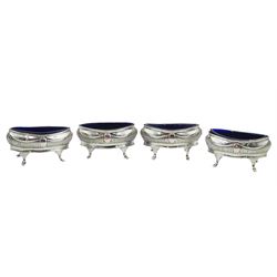 Set of four late Victorian silver salts, each of navette form upon four splayed feet, with blue glass liners, hallmarked Thomas Hayes, Birmingham 1897, approximate total silver weight 7.45 ozt (232 grams)