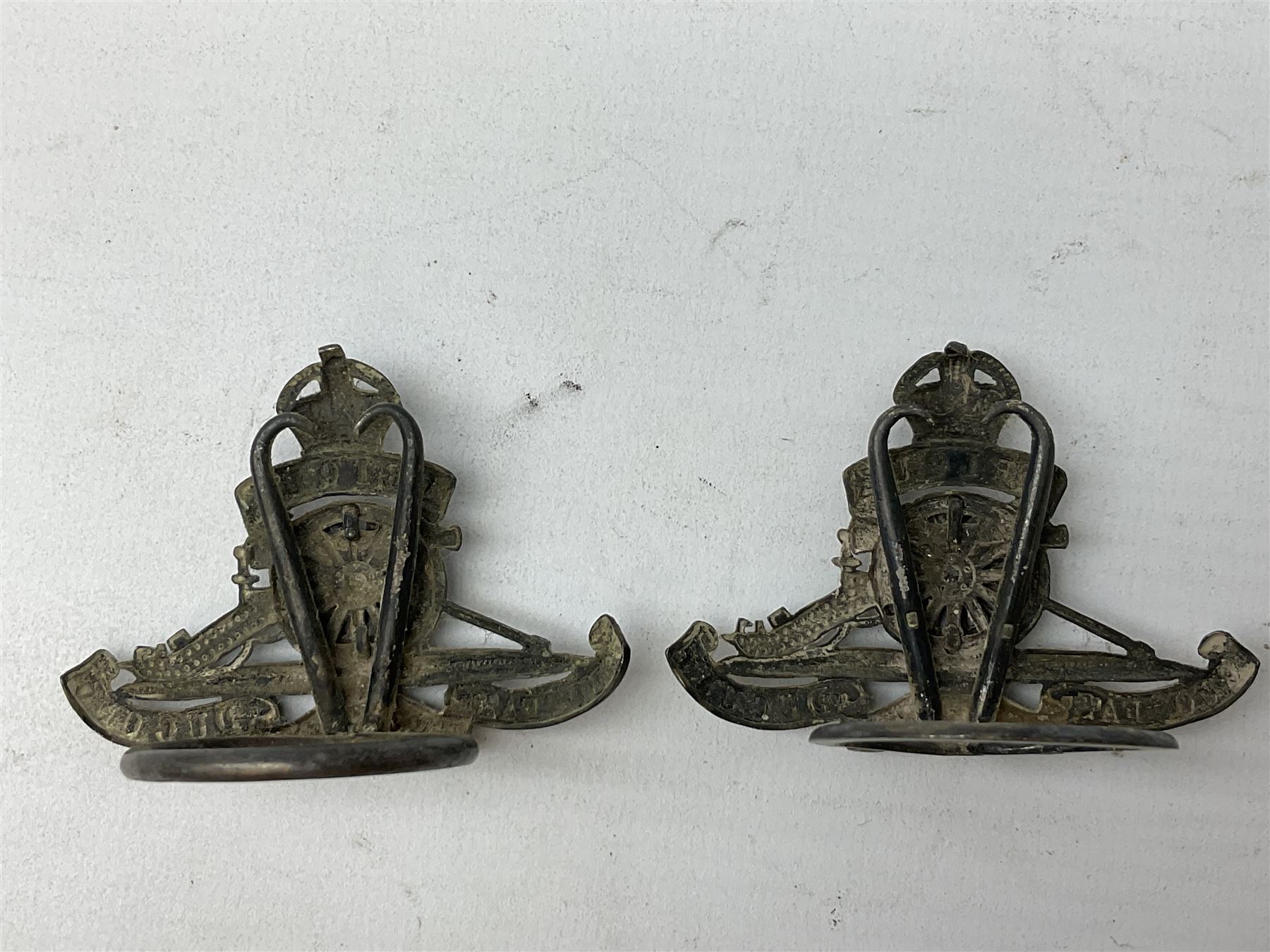 Trench Art - three WW2 brass shell case ashtrays, one mounted with Royal Artillery cap badge and button and one mounted with RA button; together with a pair of place name holders each formed from a Royal Artillery cap badge (5)