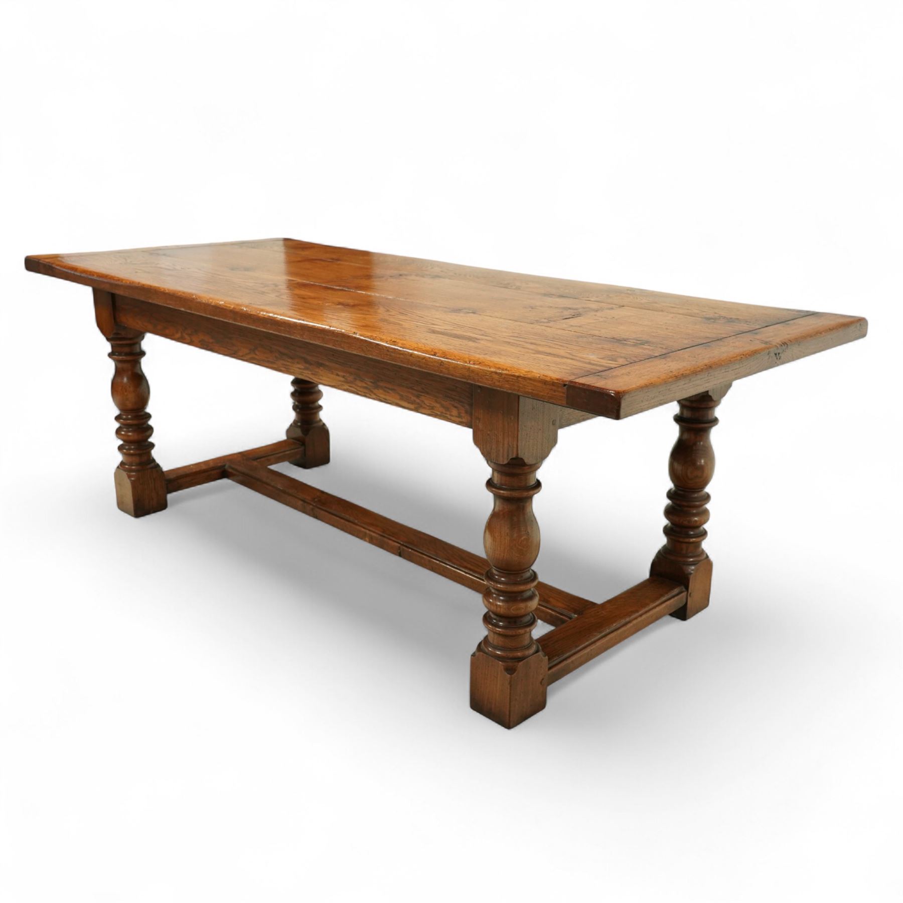 17th century design rustic oak refectory dining table, rectangular plank top over plain frieze rails, raised on heavily turned legs united by an H-stretcher  