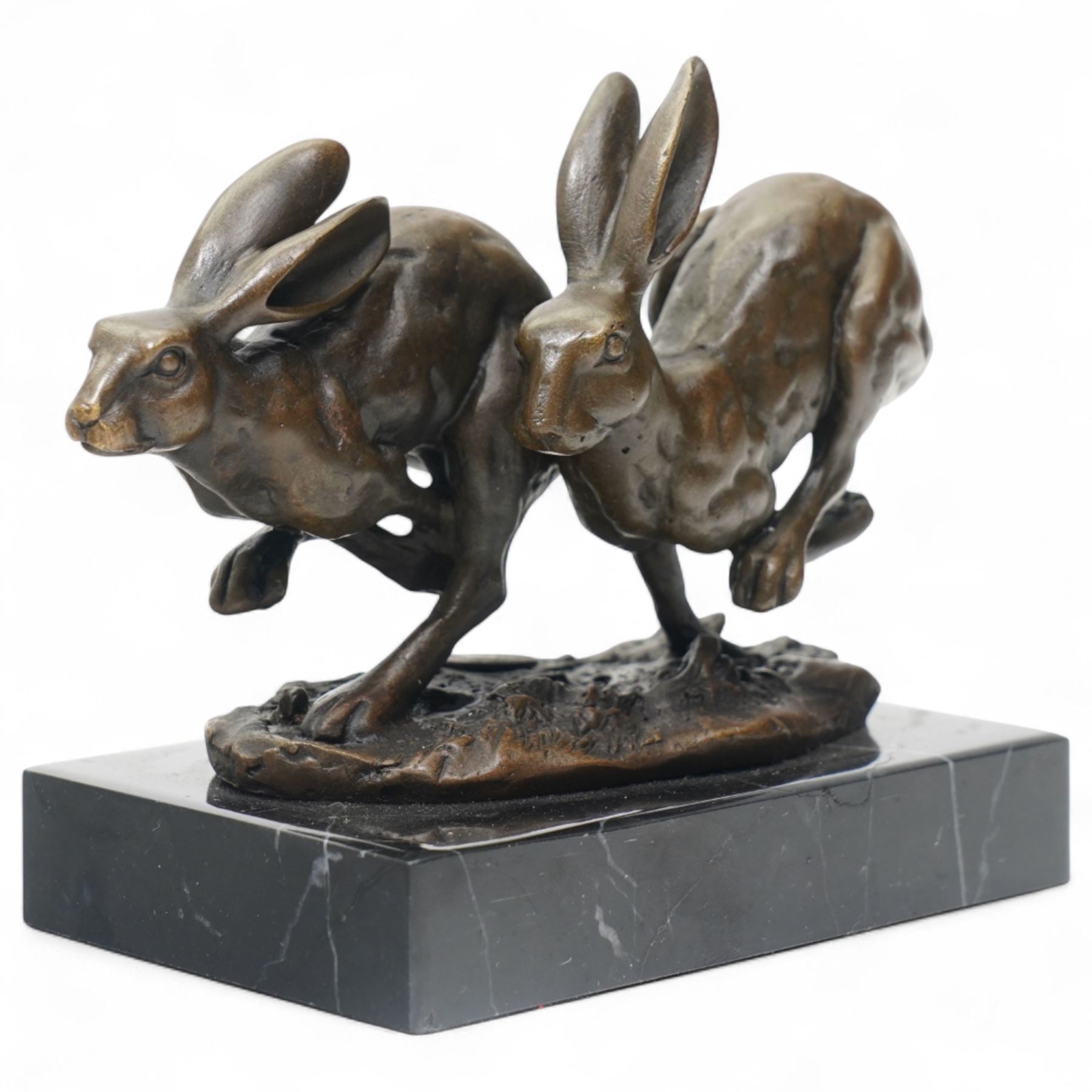 Bronze figure group modelled as two hares in chase, signed Nick and on marble base H12cm
