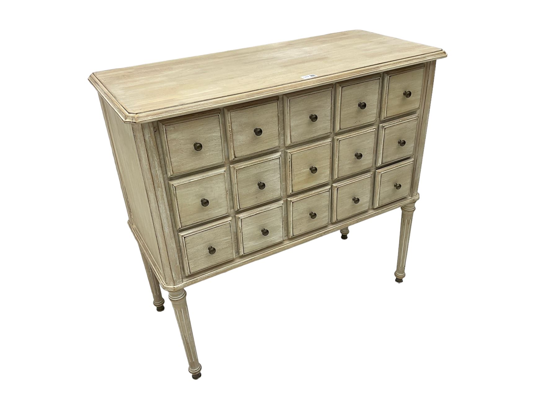 Washed finish pigeon hole or apothecary style chest, fitted with fifteen drawers, raised on fluted tapered supports 