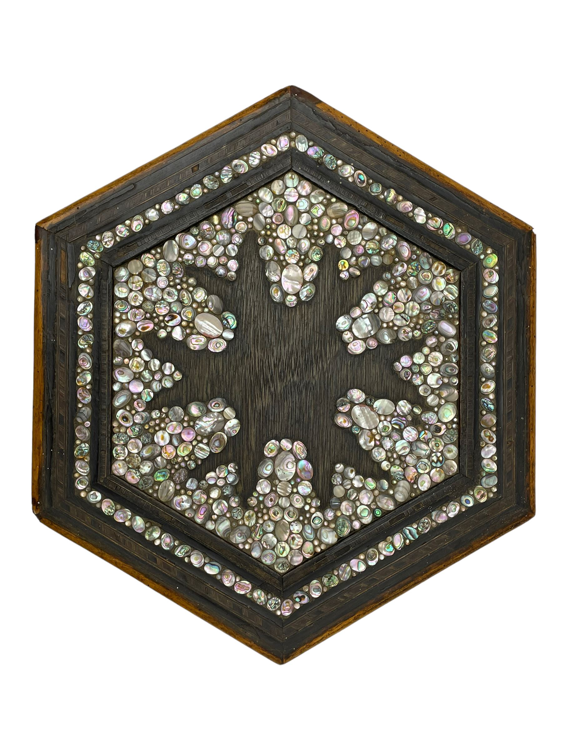 Early 20th century Anglo-Indian hexagonal table, the top decorated with mother of pearl beads and chequered banding, the base with fretwork pointed arches and inlays