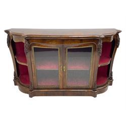 19th century rosewood buffet credenza, bombe form with shaped and moulded top, two central glazed doors with foliate moulded gilt slips, the red fabric-lined interior fitted with a single shelf, flanked by open shelves with raised gilt metal lips, the uprights decorated with shell and flower head carved cartouche mounts, acanthus leaf scroll carved lower mounts, on shaped and moulded plinth base 