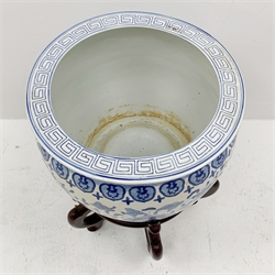 A large Chinese blue and white jardinière decorated with a band of flowers and tendrils within stylised borders, raised upon a hardwood stand, H53.5cm.
