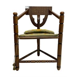 19th century swedish monk's chair, the oak frame with triangular seat and sloped arms, the backrest carved with geometric chipwork and a central pierced medallion 
