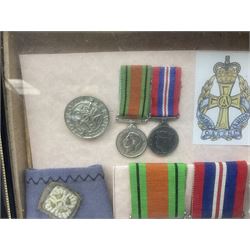 Framed display of medals and badges relating to Captain Cynthia Page of Queen Alexandra's Royal Army Nursing Corps including WW2 War Medal and Defence Medal with miniatures; Red Cross Society 3-Year Service Medal; Q.A.R.A.N.C. cap badge; Girl Guide and silver Scout badges; rank epaulettes; and related photographs 33 x 23cm