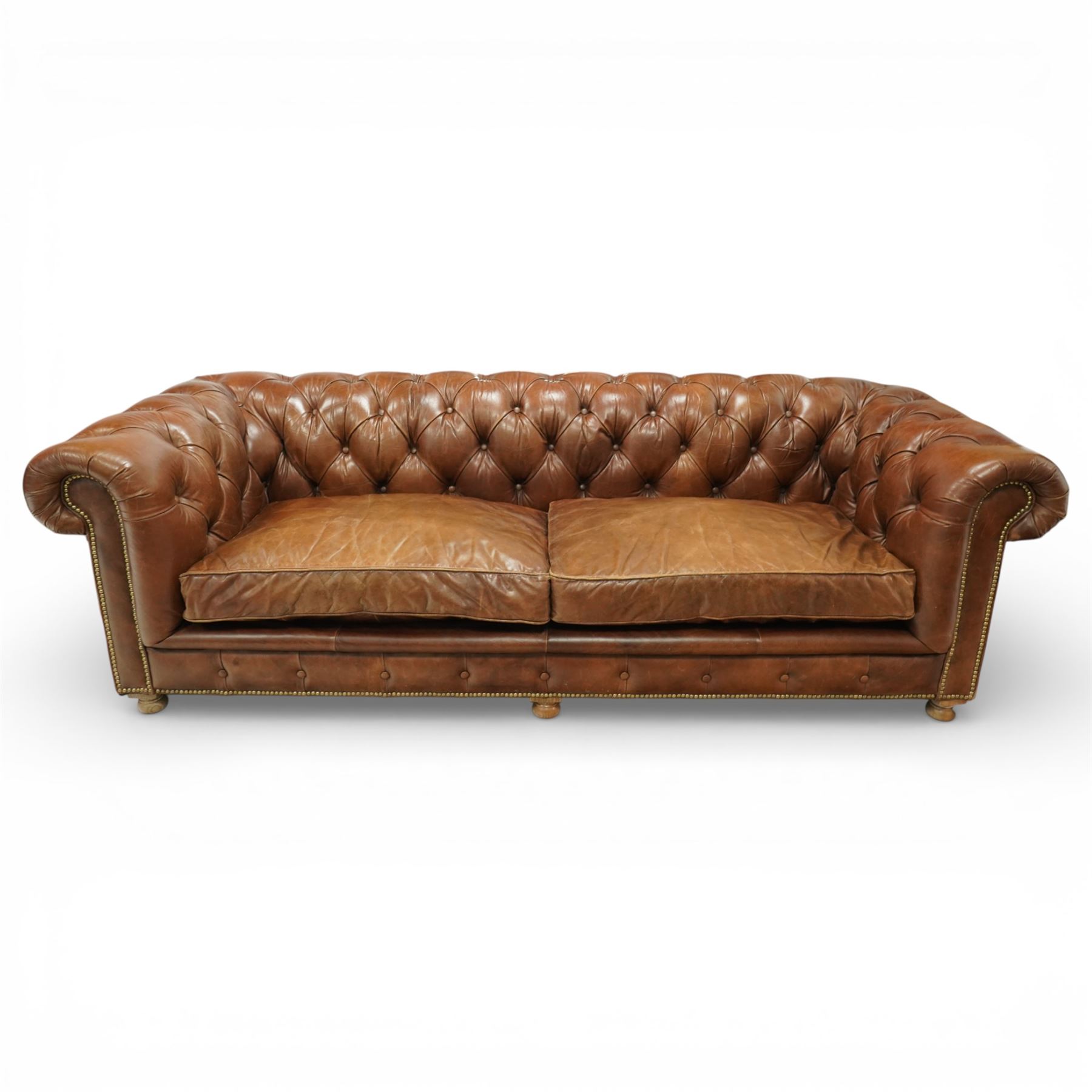 Timothy Oulton for Halo - three seat chesterfield sofa, deep button tufted back and arms in tan leather, loose seat cushions, studded detail to the scrolled arms and lower frieze, raised on turned bun feet