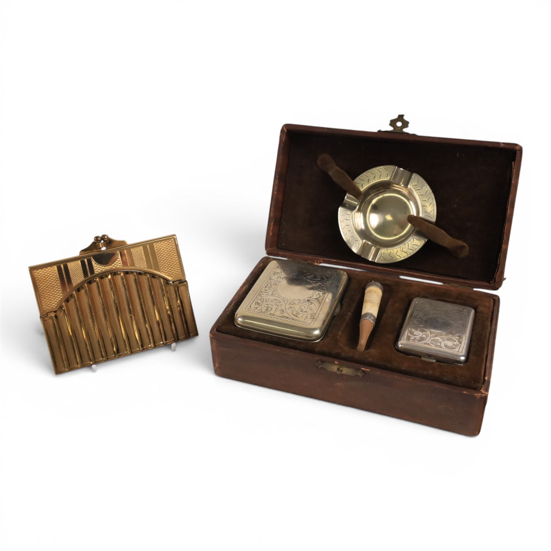 Three cigarette cases, modelled as bank notes, together with a smokers set including ashtray, cigarette case, ligher and cigarette holder, cased and other cigarette holders 