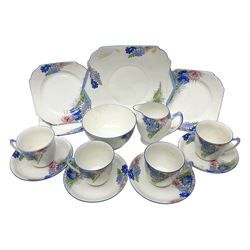 Shelley Strand shaped tea wares, decorated with blue and pink daisies upon a white ground, comprising four teacups, four saucers, three tea plates, milk jug, sugar bowl and cake plate, all with printed green mark beneath and painted pattern no 12216