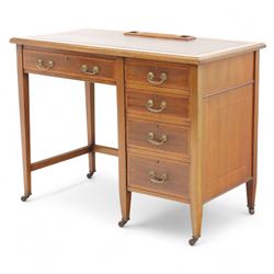 Early 20th century Edwardian mahogany single pedestal writing desk, the crossbanded rectangular top inset with brown leather, fitted with five drawers with brass swan neck handles, upon square tapering supports terminating in brass castors
