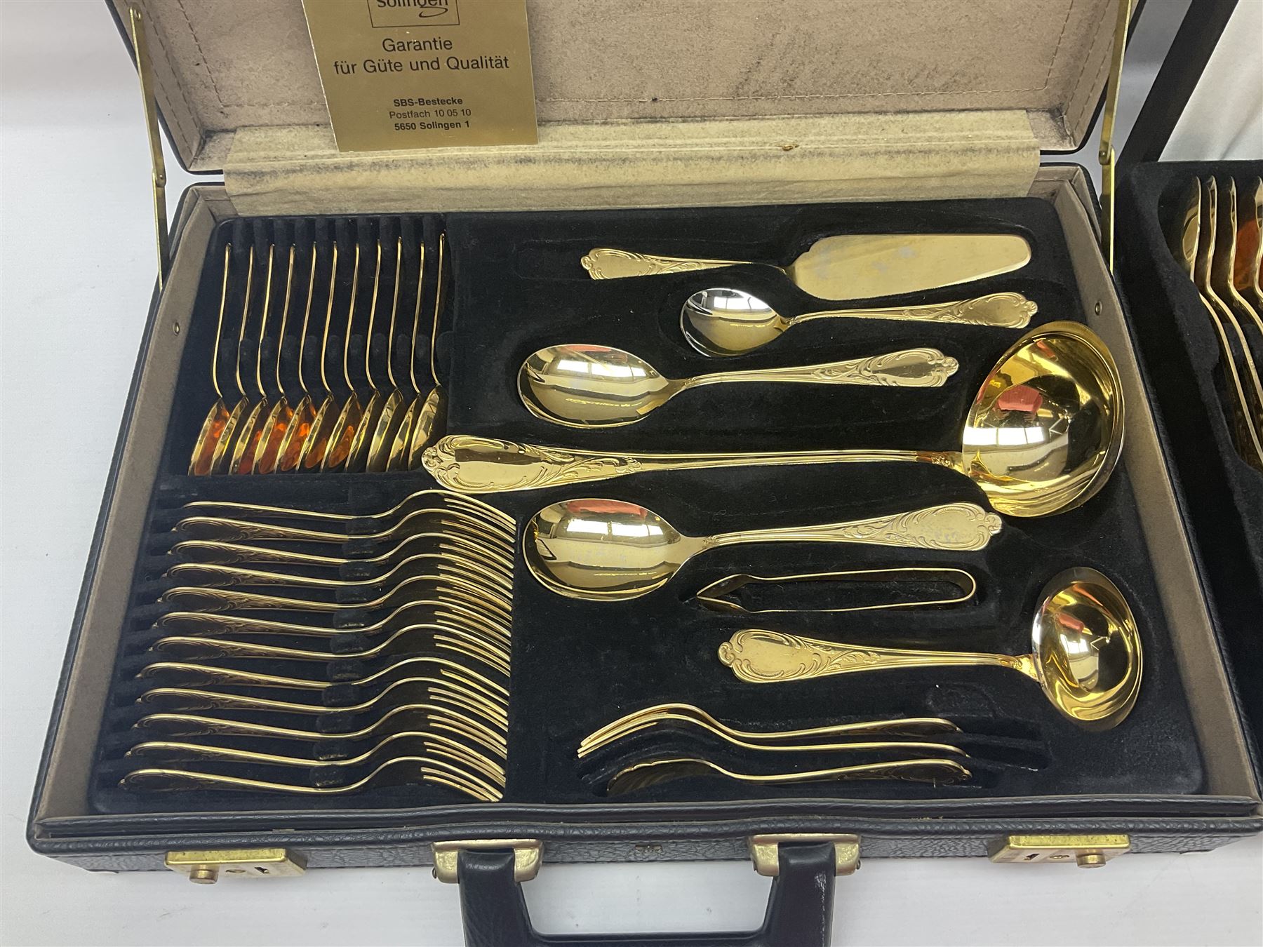 Bestecke Solingen canteen of gold plated cutlery for twelve place settings, including ladle, cake slice and serving spoons, contained within a briefcase, together with a matching set twelve of Bestecke Solingen gold plated fish knives and forks, in fitted case 