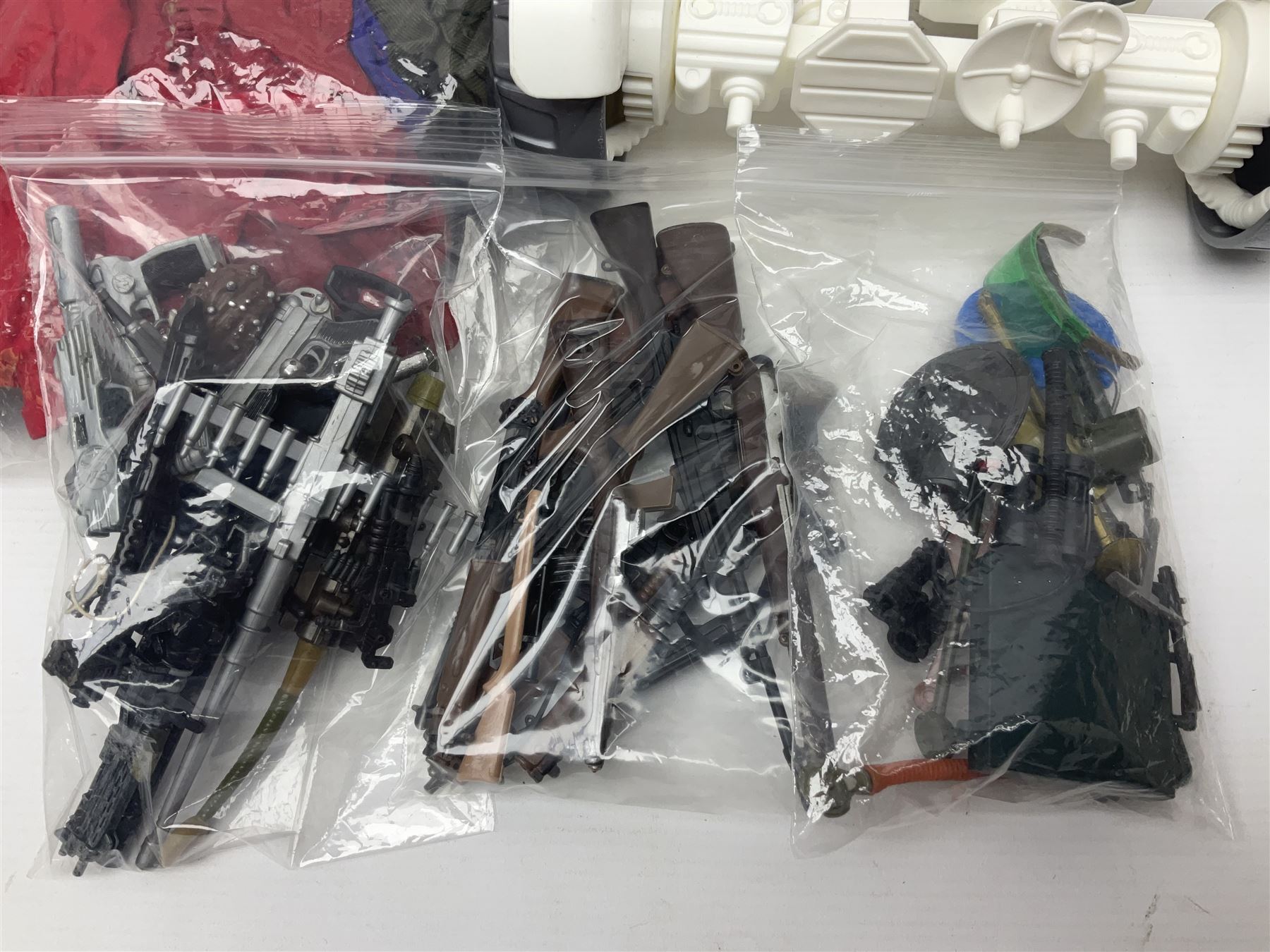 Action Man - large collection of 1960s and later figures and accessories including Spaceman with ATLRV vehicle; two figures marked 'Made in England by Palitoy under licence from Hasbro 1964'; twenty-five assorted weapons; radio backpacks; kit bags; twenty-one pairs of boots; football boots and snow shoes; metal diver's boots and three pairs of flippers; two pairs of jackboots; roller skates; various tunics, trousers, flying suits, jumpers, belts etc; twenty helmets, berets, busby, kepis, submariner etc; and quantity of other accessories