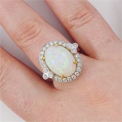 18ct white gold opal and diamond cluster ring, single cabochon cut opal of approx 5.20 carat, surrounded by round brilliant cut diamonds, in a milgrain setting, stamped 750, total diamond weight approx 0.55 carat