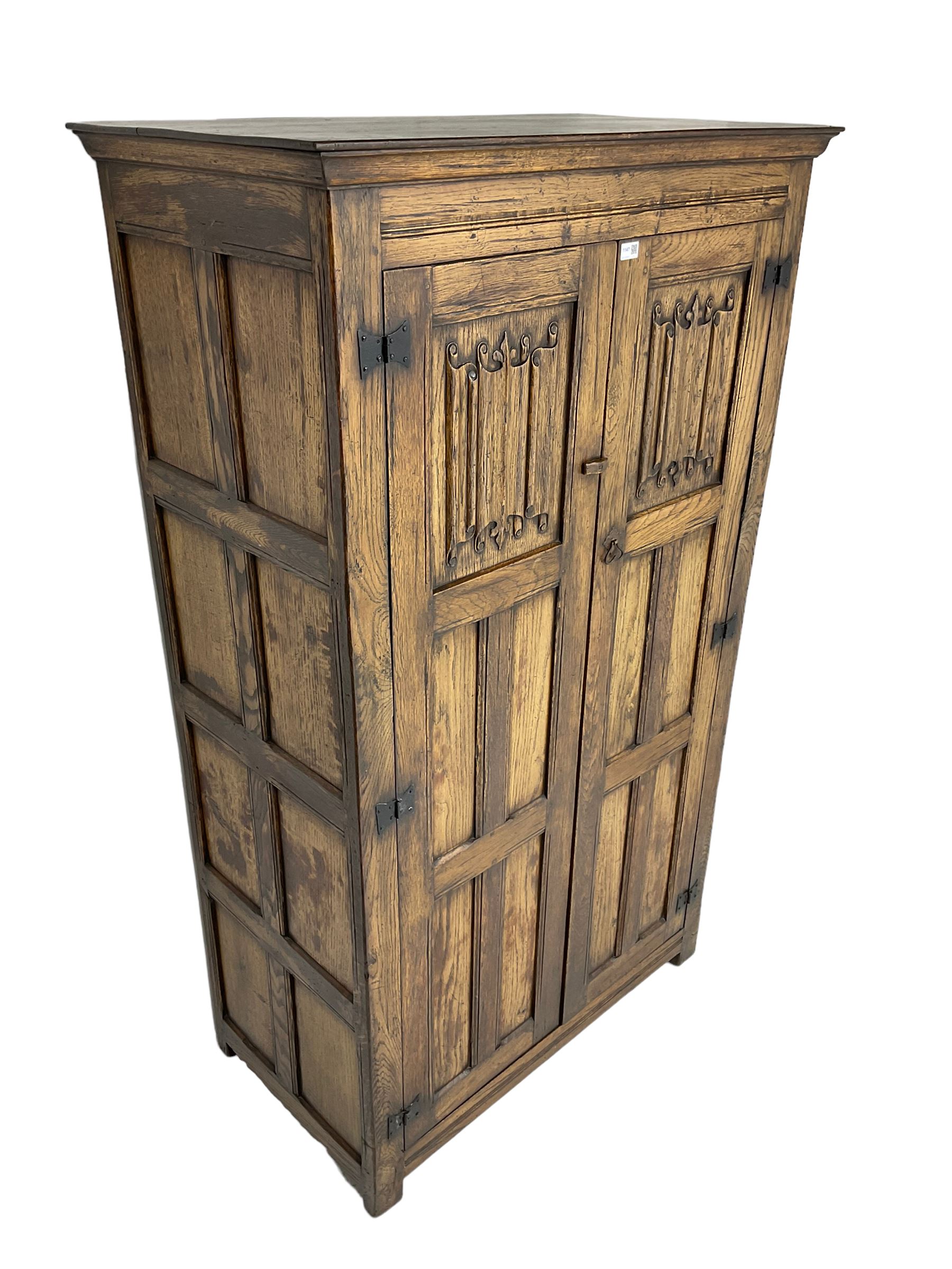Mid-to-late 20th century oak double wardrobe, enclosed by panelled doors with linenfold decoration