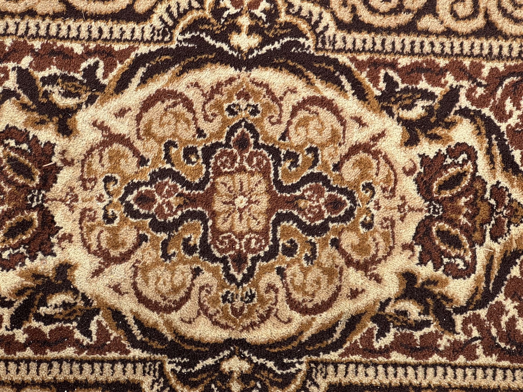 Persian Tabriz ivory ground rug, the field centred by a shaped floral medallion with swirling spandrels, richly decorated with foliate motifs, the broad border with matching cartouches and palmettes, within multiple guard stripes