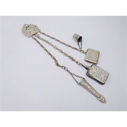  Early 20th century silver-plated Chantelaine, pierced scroll mount, three mask chains to a mask embossed scissor sheath, pin cushion & thimble and engine turned silver vesta, L24cm excluding attachments   