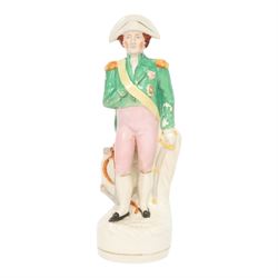 Rare mid 19th century Staffordshire pottery figure of Admiral Lord Nelson, modelled standing in uniform with green tunic, beside anchor, H27cm