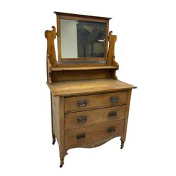 Arts & Crafts period oak dressing chest, raised swing mirror over three graduating drawers, shaped apron, on turned supports with castors