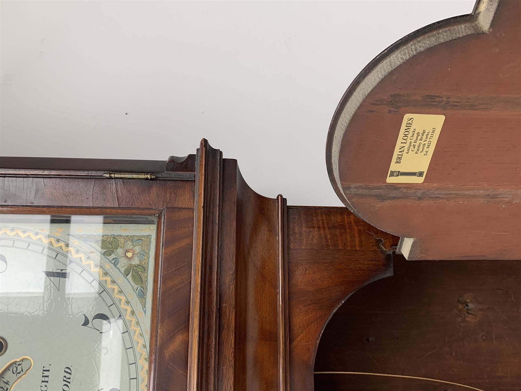 George III mahogany longcase clock, the hood with stepped moulded arch pediment above glazed door, fret work grille to each side, figured trunk door and base, enamel Arabic dial painted with country house scene and floral spandrels signed 'S. Wright, Watford', subsidiary seconds dial and date aperture, eight day movement striking the hours on bell, H212cm (two weights and pendulum)