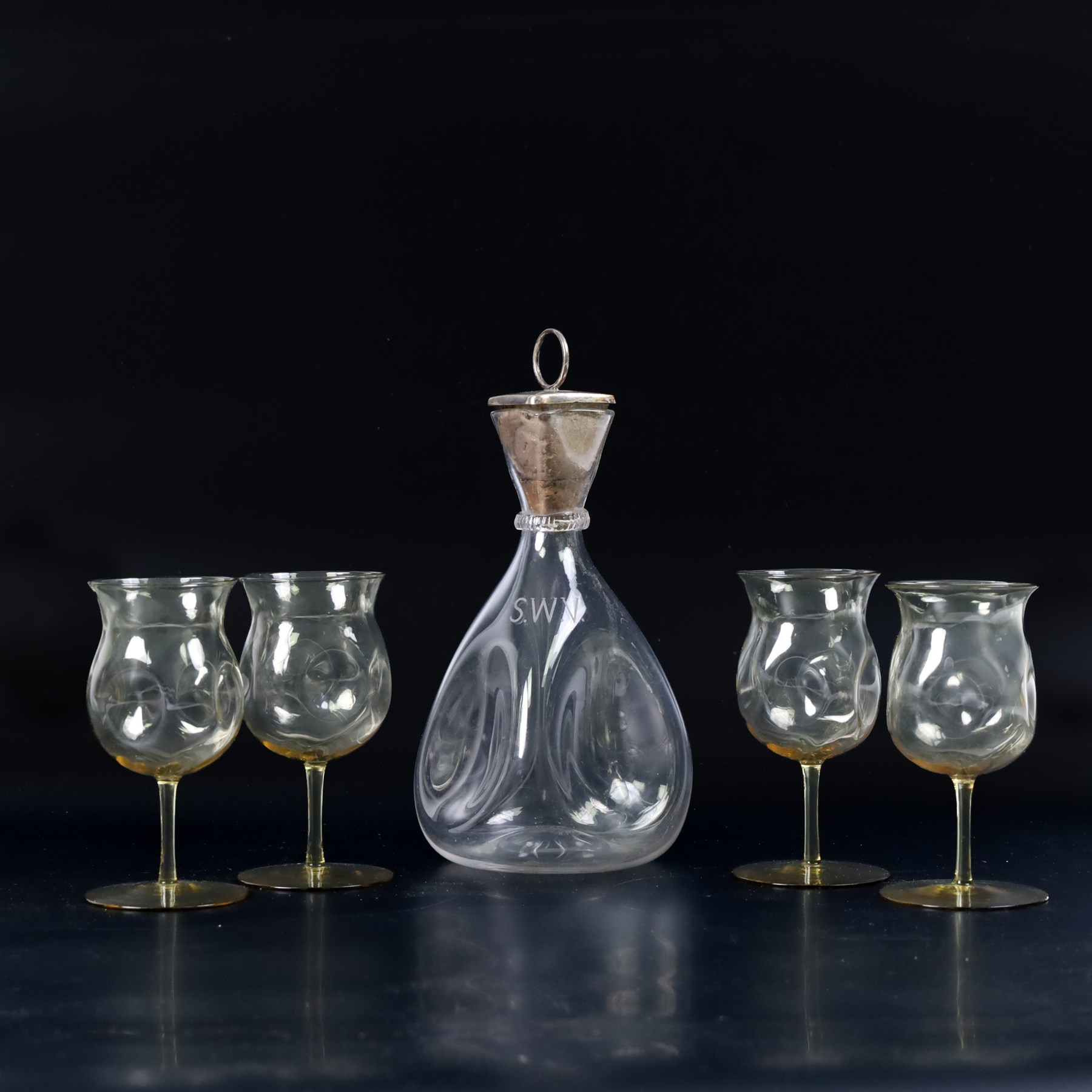 Four Arts and Crafts drinking glasses of dimple form, probably James Powell, Whitefriars, together with a dimple decanter, glasses H12cm