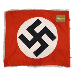 German Third Reich NSDAP flag, with central swastika, blue edged brown panel to the corner with “Łodygowice” embroidered in white, later silver tress added to the edge