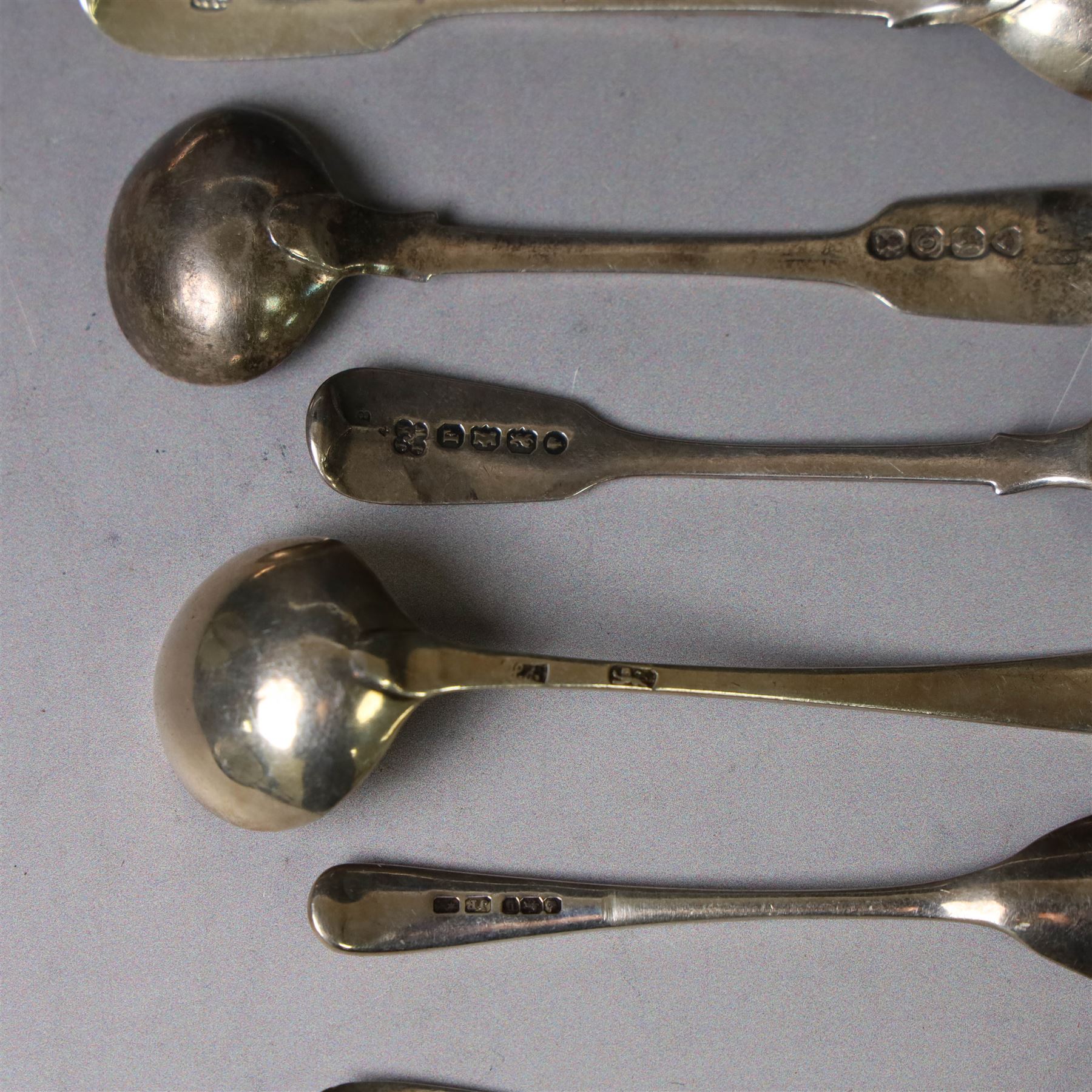 George III silver marrow scoop, hallmarked London 1767, makers mark indistinct, together with a collection of silver condiment spoons and butter knives, all hallmarked