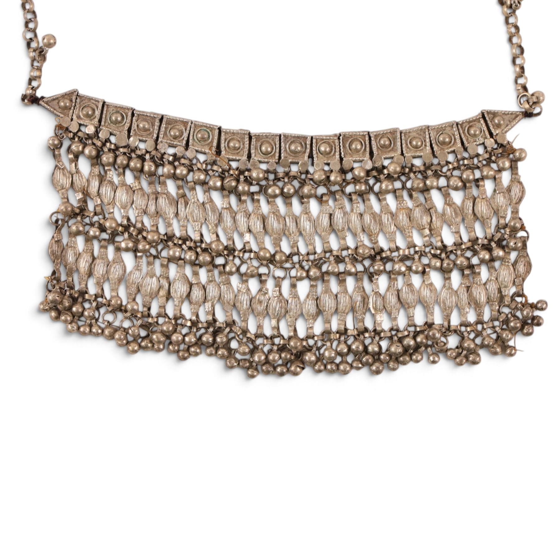 Collection of Middle Eastern jewellery, including silver necklace with a crescent  shaped pendent with beadwork and barrel tasselled ends, nickel silver wedding necklace with filigree decoration, coin bracelet, two bridal wedding caps and two others 
