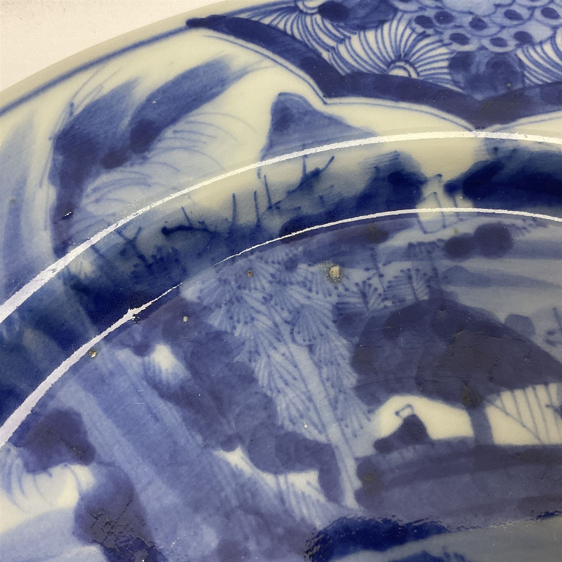 Japanese Meiji period Arita blue and white plate, of circular form, painted with riverside landscape and bird upon flowering branch, with character mark beneath, D24.5cm, together with two 18th century Chinese blue and white plates, each painted with floral design, each approximately D22.5cm