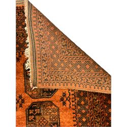 Afghan Bokhara dark amber ground rug, field decorated with three central Gul motifs, heavily guarded border with repeating geometric patterns