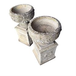 Pair of quality Neoclassical design Haddonstone cast stone garden urns, the globular  body decorated with relief foliate festoons and fruiting motifs, over a fluted socle, the rectangular pedestals with relief foliate wreaths and ribbon garlands