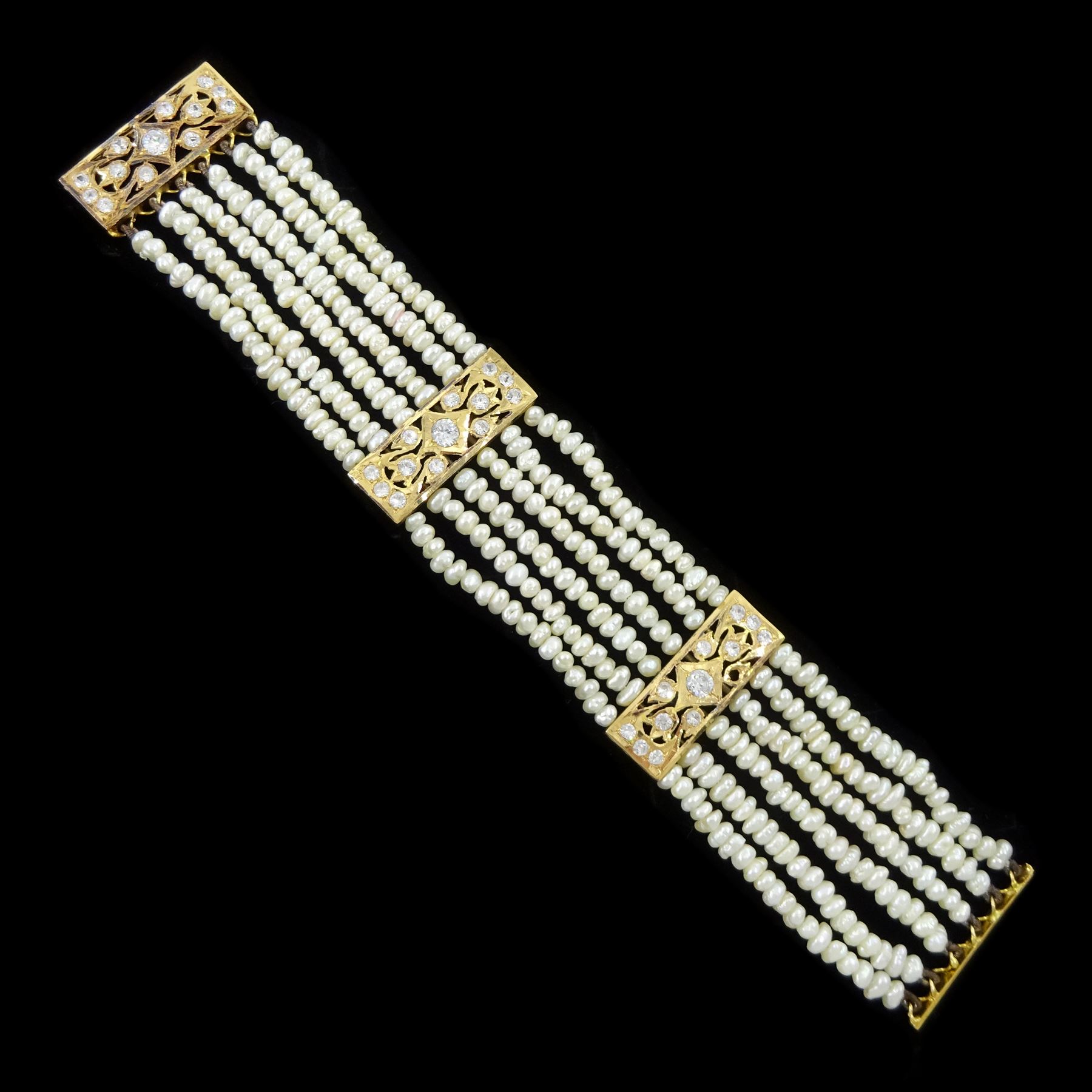 18ct gold pearl and white paste stone bracelet, six strands of cultured white pearls, spaced by openwork gold panels set with paste stones