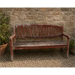 Teak garden bench, with slatted seat and spindle back, shaped armrests, finished in weathe...