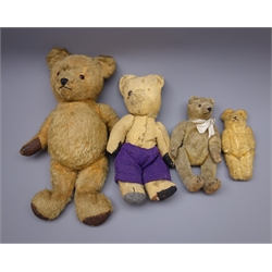  Mid-20th century teddy bear with plush covered straw filled body, revolving head with applied eyes and stitched features and jointed limbs with rexine pads H42cm, early 20th century straw filled teddy bear and two others (4)  