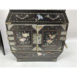  Late 19th / early 20th century Japanese lacquered table top cabinet, heavily decorated with mother of pearl inlay depicting blossoming branches, flowers and birds, the two hinged doors between longer drawers opening to reveal interior fitted with four short drawers, with lift up hinged canted lid, H28cm D9.5cm W23cm, together with mother of pearl inlaid miniature folding screen, dish decorated with walking figures with crimped edge, boxes decorated with flowers, birds and gilt etc