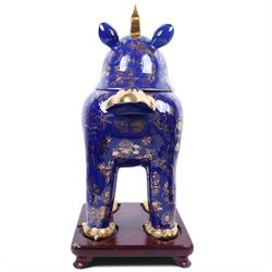 Pair of 20th century foo dog incense burners, decorated with gilt flowers and insects upon a blue ground, on wooden stands, H58cm 