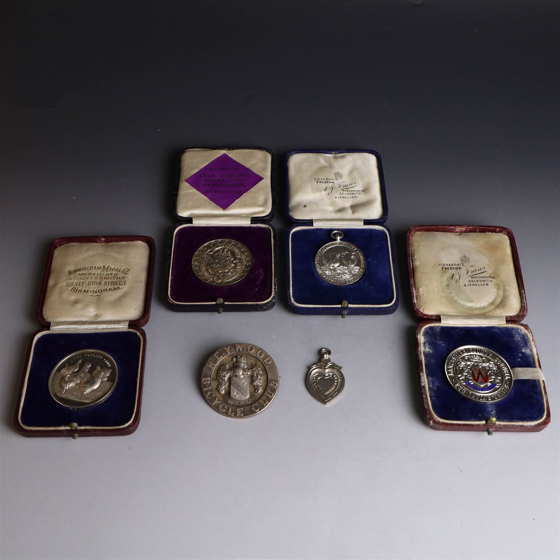 Collection of silver medals, mainly with an agricultural theme, including Poultry Club, Heywood Bicycle Club, heart shaped fob, four within leather cases 