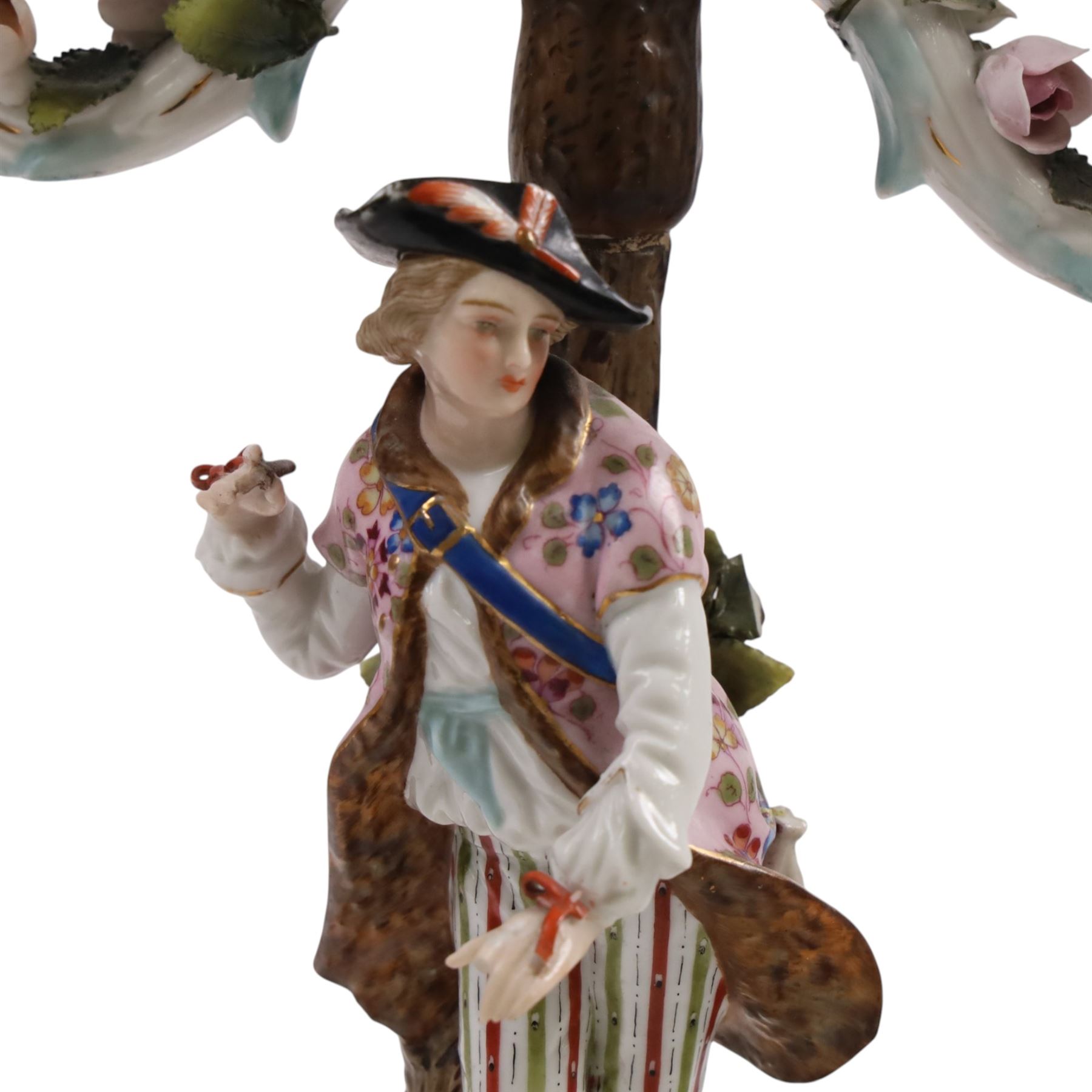 Pair of 19th Century German three-branch figural candlesticks, the figures each in floral dress against a tree, the branches decorated in relief with roses and the sconces painted with insects, H33cm 