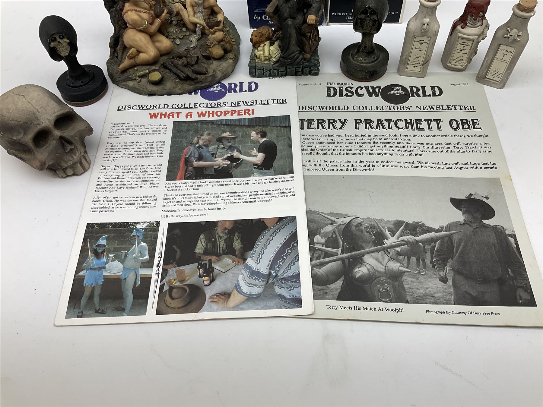 Terry Pratchett Discworld figures, designed by Clarecraft, comprising Cohen the barbarian, DW42, the Patrician, boxed, DW37, three Potions, DW18, DW19, DW20, two Death Bookstamps, DW50, the Gods Dice Box, boxed, DW26, together with two Discworld newsletters, volume 5, August 1998 and volume 6, August 1999. 