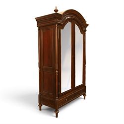 And So To Bed - French design ‘Eclectic’ double wardrobe in dark finish, arched moulded cornice with carved foliate band and turned finials, two mirrored doors enclosing a hanging rail, flanked by turned columns with foliate decoration, single fluted drawer below, on turned tapering feet
