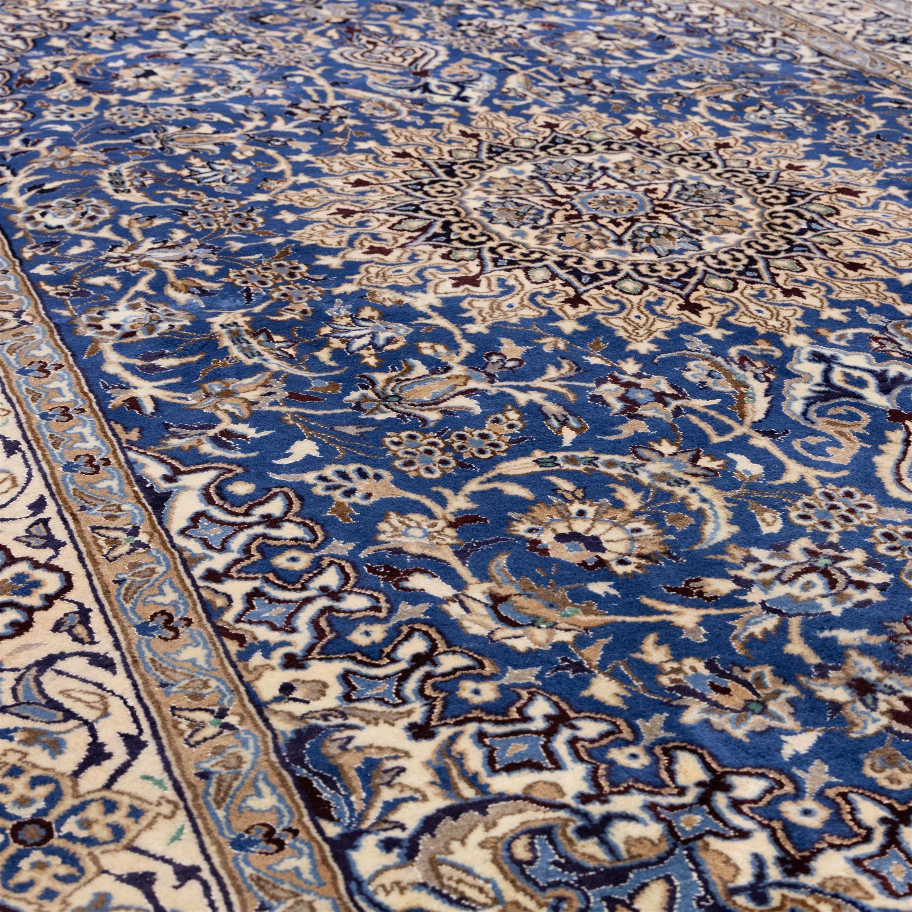 Central Persian Nain hand-knotted rug, soft blue field with central medallion with finely drawn scrolling palmettes and floral tendrils, with ivory spandrels, enclosed by a floral meander border flanked by multiple guard stripes with cotton fringe ends 