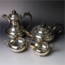 Mid 20th century silver four piece tea service, comprising teapot, hot water pot, open sucrier and milk jug, all of squat bellied form, the teapot and hot water pot with ebonised handles and finials, hallmarked Walker & Hall, Sheffield 1953, hot water pot H19cm