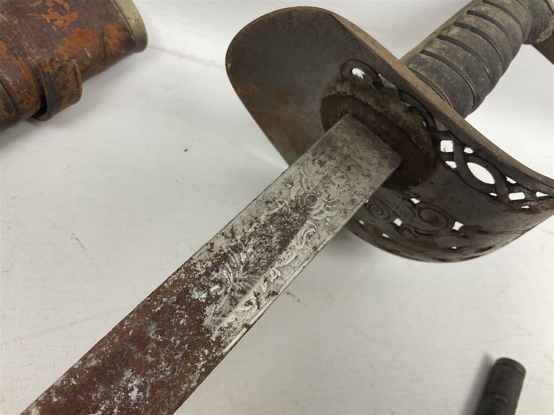 George V 1897 pattern Infantry officers sword, the 82cm single fullered blade with traces of etched detail and George V crown cipher, the ricasso marked Hawksworth Sheffield, pierced half basket hilt with George V cypher, wire-bound fish-skin grip with brass pommel and backstrap; in leather scabbard L102cm overall; together with two sectional gun cleaning rods; swagger stick made of leather strips etc