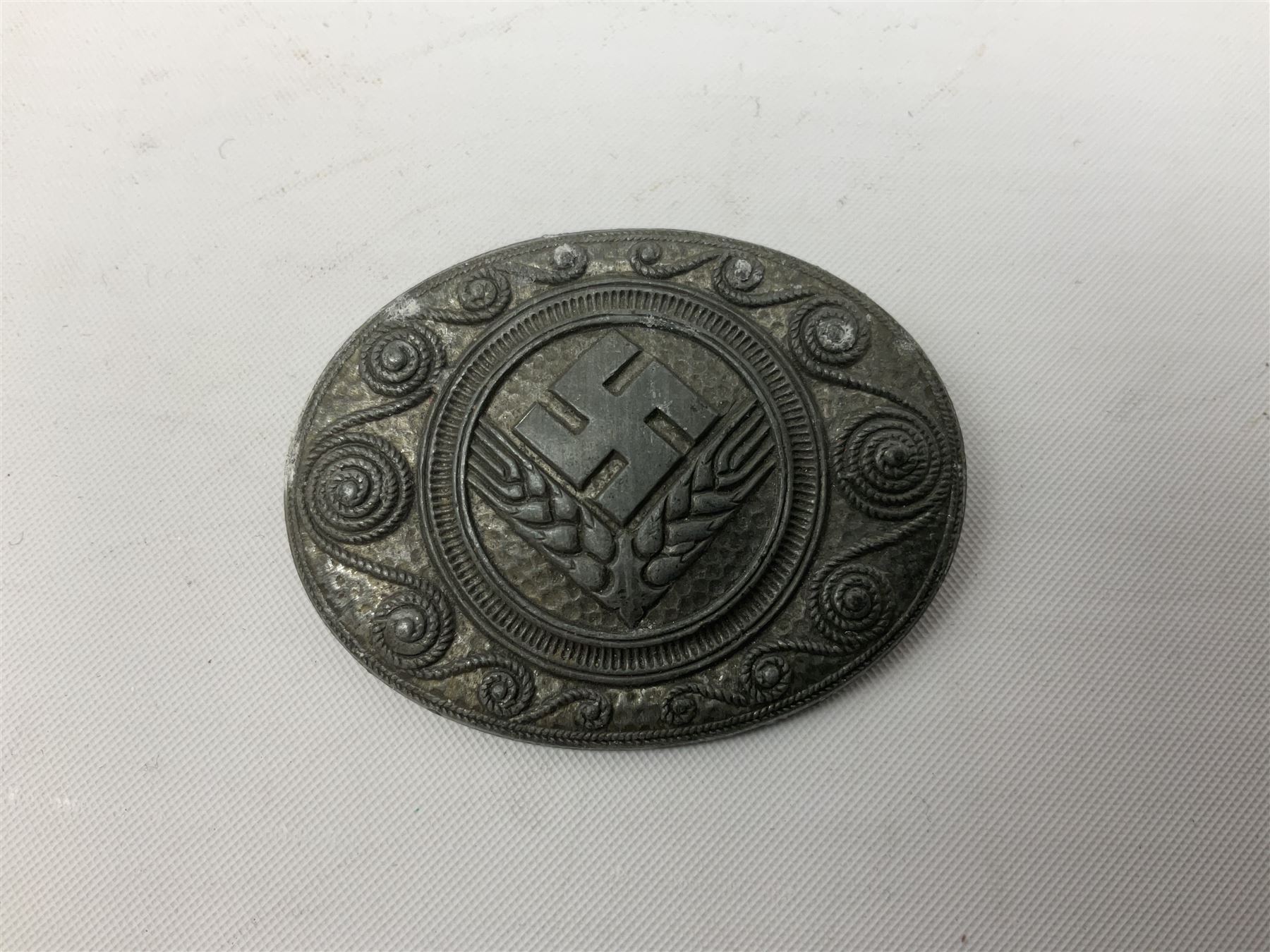 Two WW2 German Army Afrika Korps pith helmet metal side badges; RAD oval metal badge by J.B.u.Co.; WW1 German 1914-1915 bar brooch; and Nienburg War Veteren's Association badge (5)