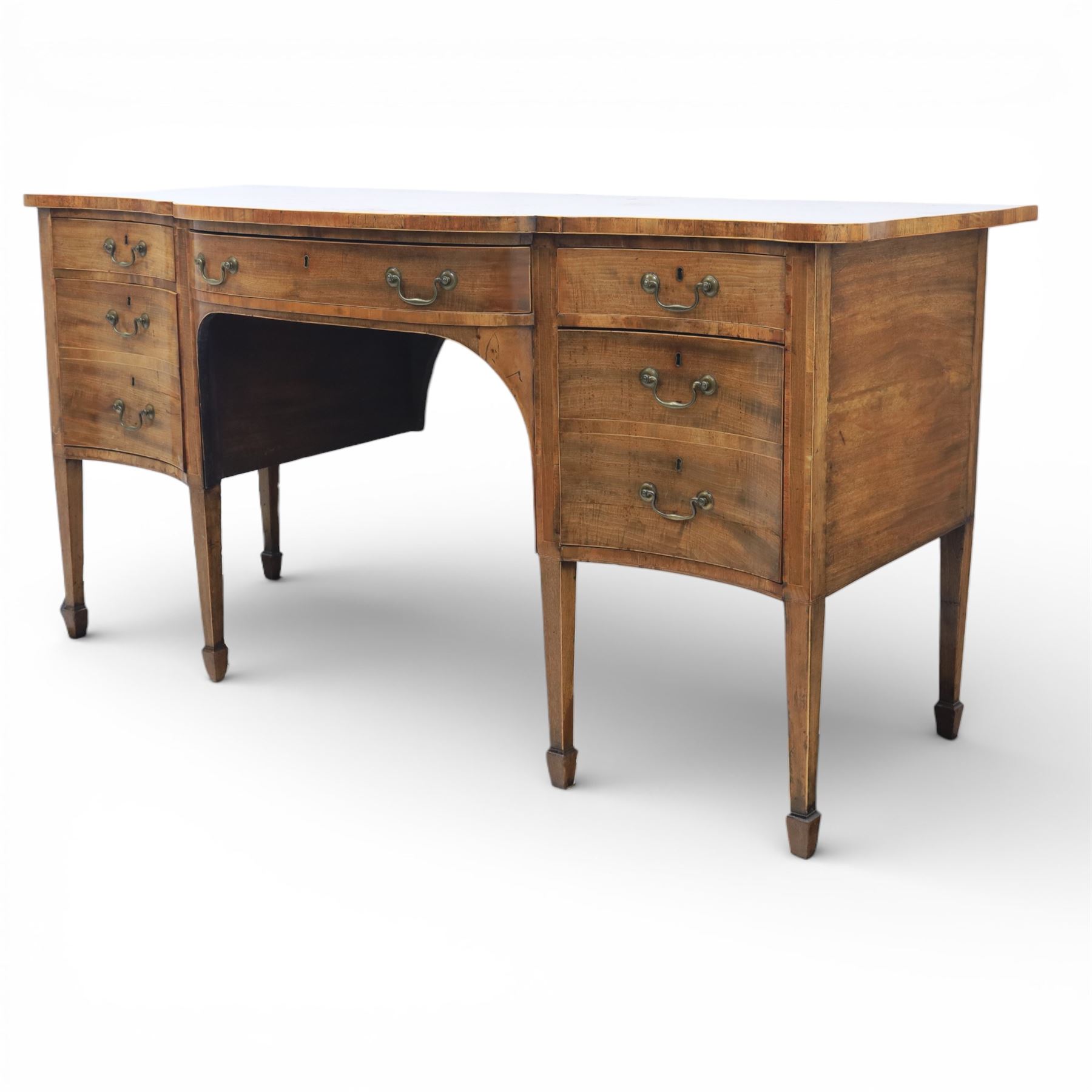 Early 20th century mahogany bow front sideboard, the shaped and moulded top above central kneehole recess with baize lined frieze drawer, flanked by twos drawers either side with the lower drawer double height, raised upon square tapering legs with spade feet