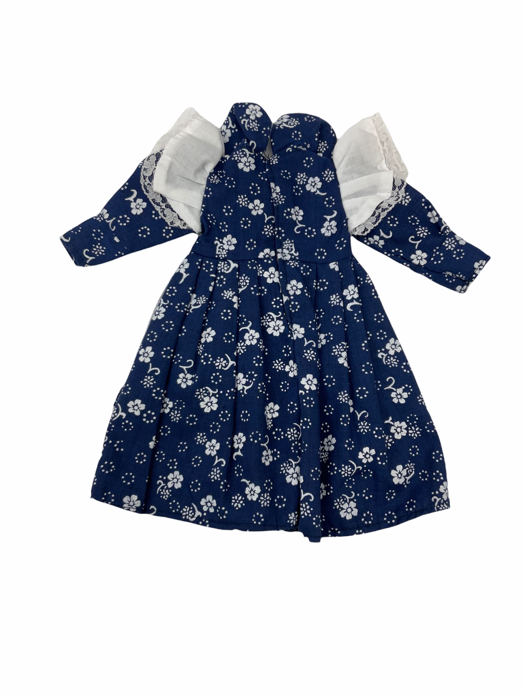 Heidi Ott doll in tartan dress, navy floral dress with white lace and ribbon detailing, striped blue and white dress and a 'Head to Toe' book